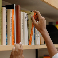 Person pulling book off of shelf