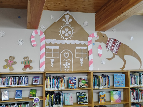 A photo of wall art at the Thorndale Library. Three gingerbread men, a gingerbread house and a gingerbread t-rex. 