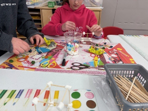 Two children work together at a table completing science experiments.
