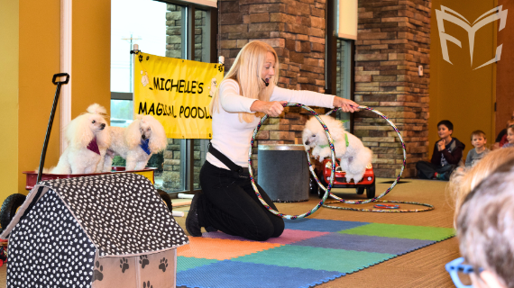 Michelle's Magical Poodles performing a ring jump trick. 