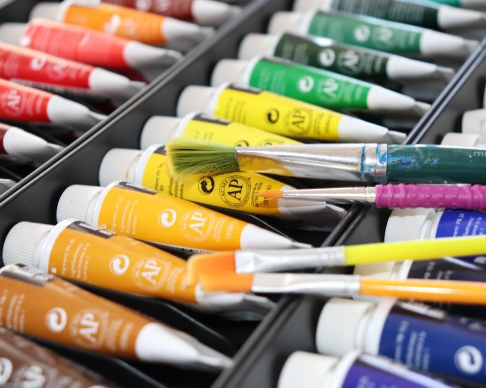 photo of acryllic paint tubes with paint brushes