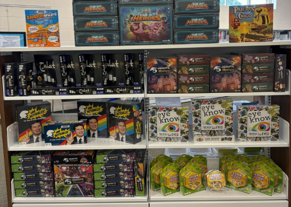 A photo of a large number of different board games arranged on a library shelf.