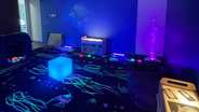 A photo of a dark room with coloured lights and glowing objects,