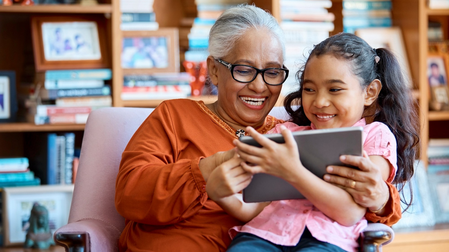 Grandmother and Grandchild Using Tablet in the Library