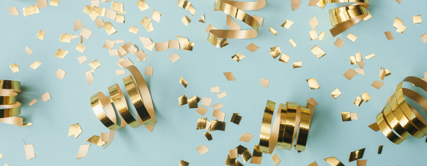 A scattering of gold confetti and curled ribbons