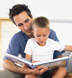 adult male reading book to child