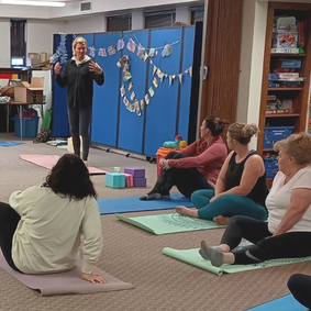 Photo of the instructor and participants of Powers Memorial Library's gentle yoga session inside the library.