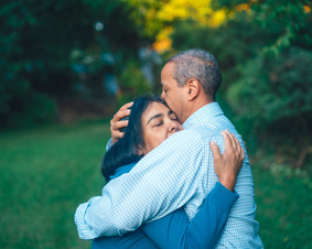 Stock photo of two people hugging outdoors.