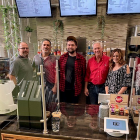 Photo of cafe owners, a staff member, Senator Dan Knodl and Supervisor Jeremy Walz behind the counter of Latitude Café in the Menomonee Falls Public Library.