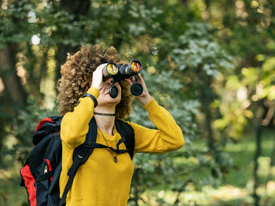 Woman using binoculars outside