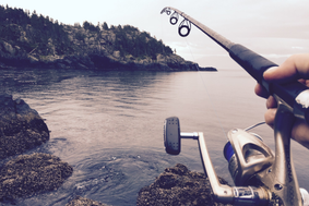 Hand holding a fishing pole cast into a lake. Hand holding a fishing pole cast into a lake.