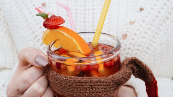 Stock photo of a hand holding a festive drink in a glass mug. Stock photo of a hand holding a festive drink in a glass mug.