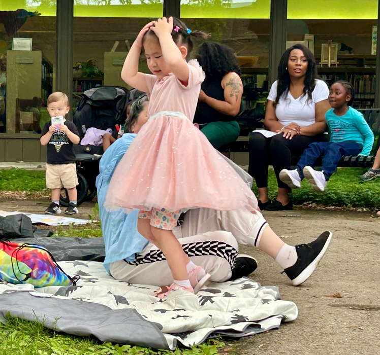 Child twirling at Family Time in the Courtyard