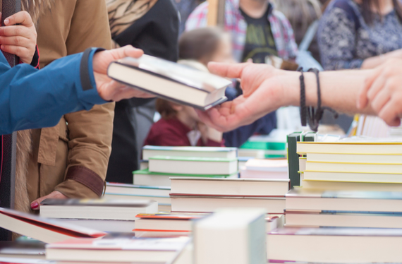 A person selling a book to another person.