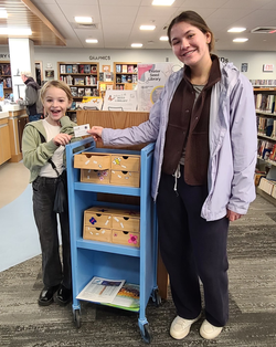 Two kids smile by a display of flower seeds Two kids smile by a display of flower seeds
