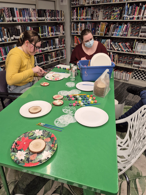 A teen and Librarian Shelby decorating ornaments in the Teen Scene.