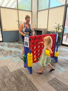 A patron and her daughter playing Giant Connect 4 at the Kickoff Party.